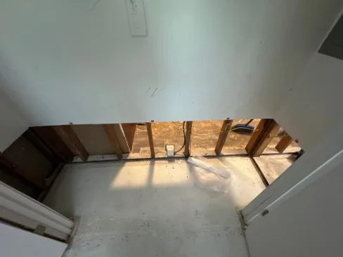 Water-damaged drywall and insulation removed from an apartment wall after flood water intrusion