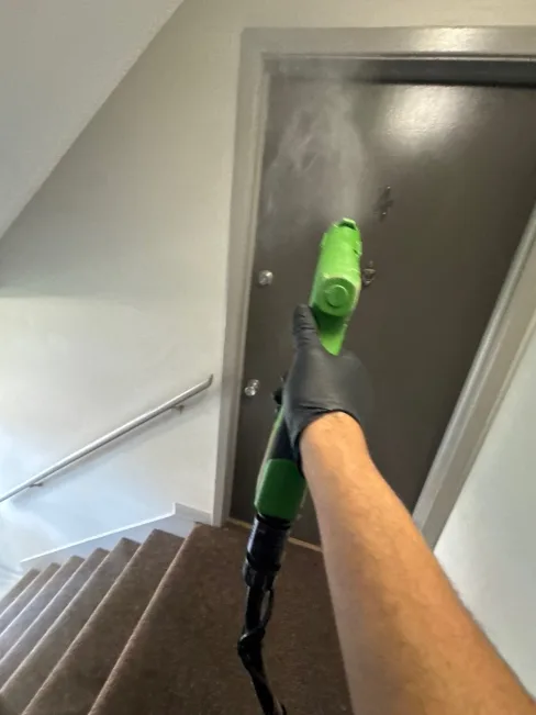 Electrostatic sprayer applying antimicrobial to surfaces in a flood-damaged apartment unit