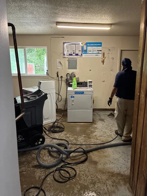 EMS crew removing flood-damaged materials from an occupied apartment building